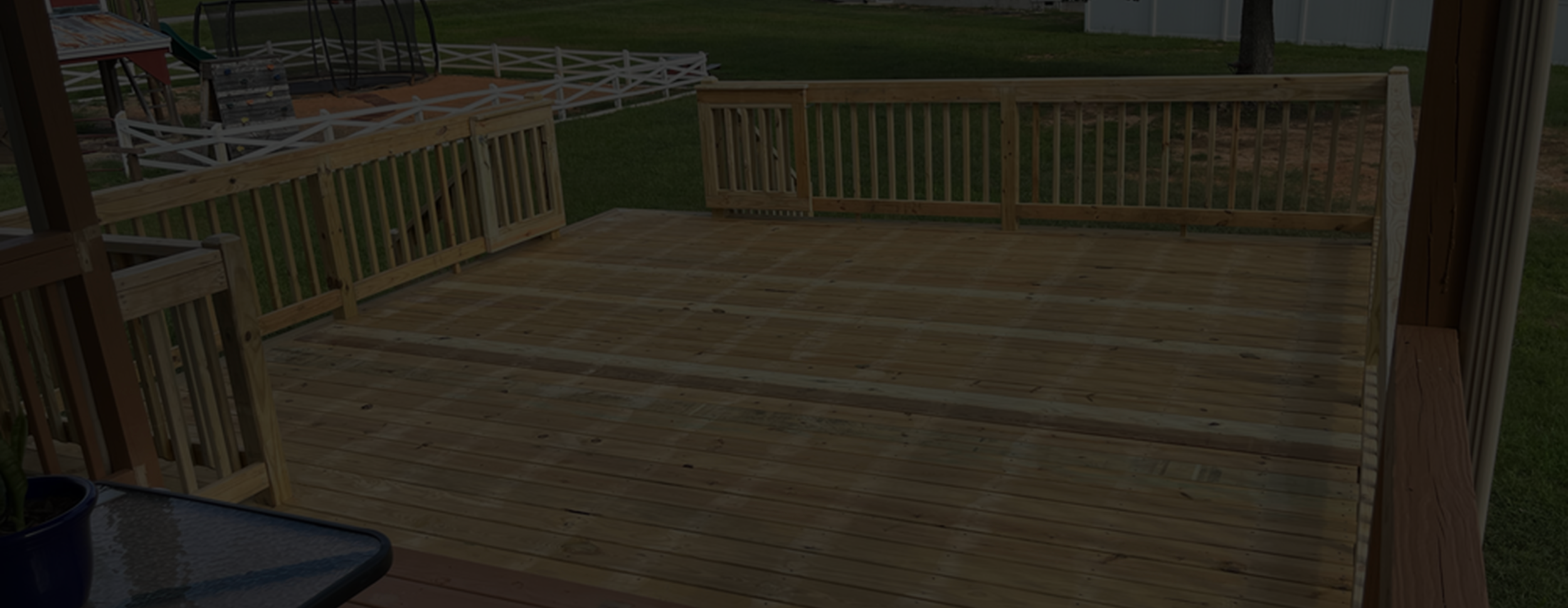 a deck with a fence and grass